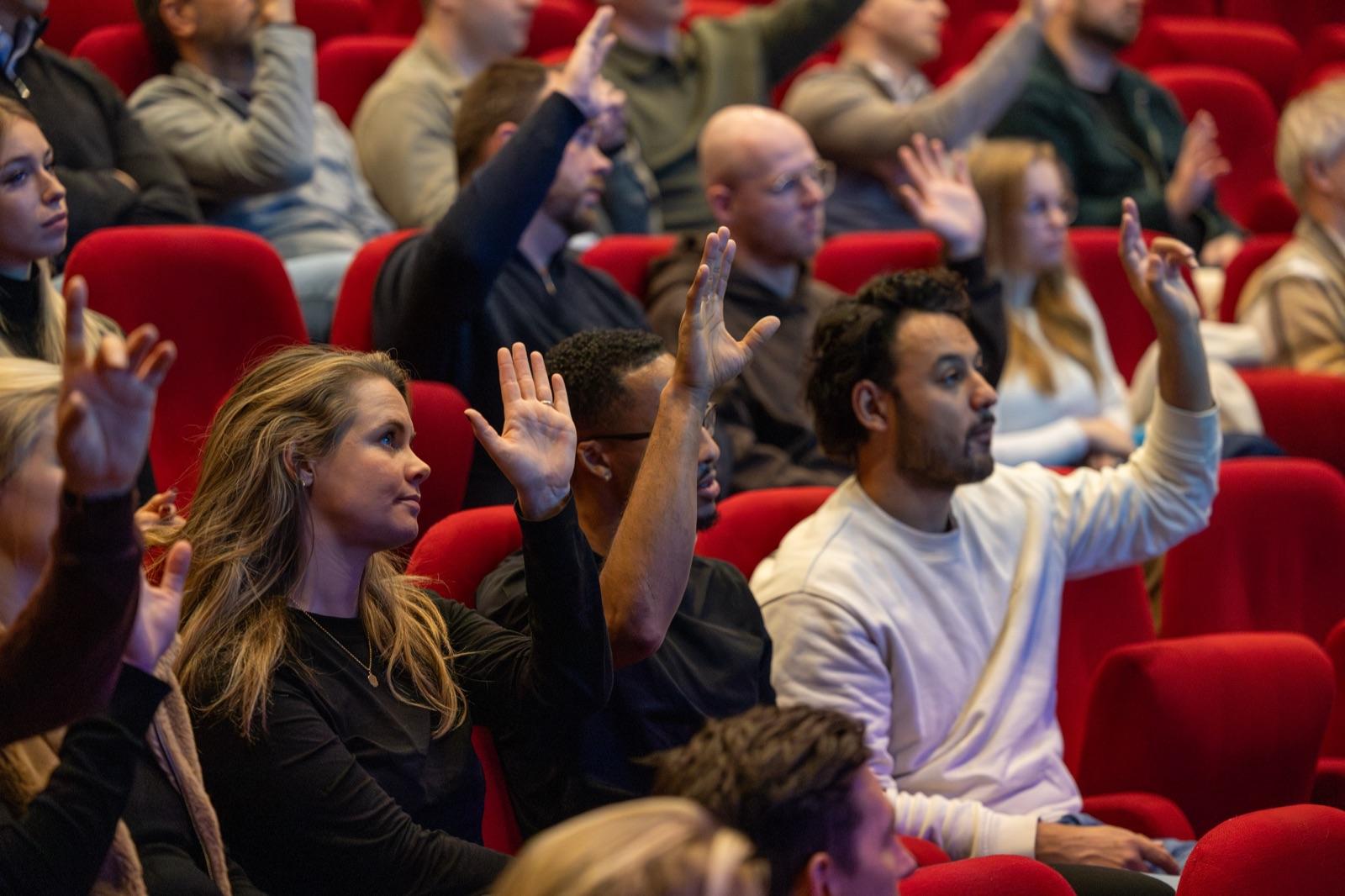 Publiek steekt de handen op tijdens een IWB-event